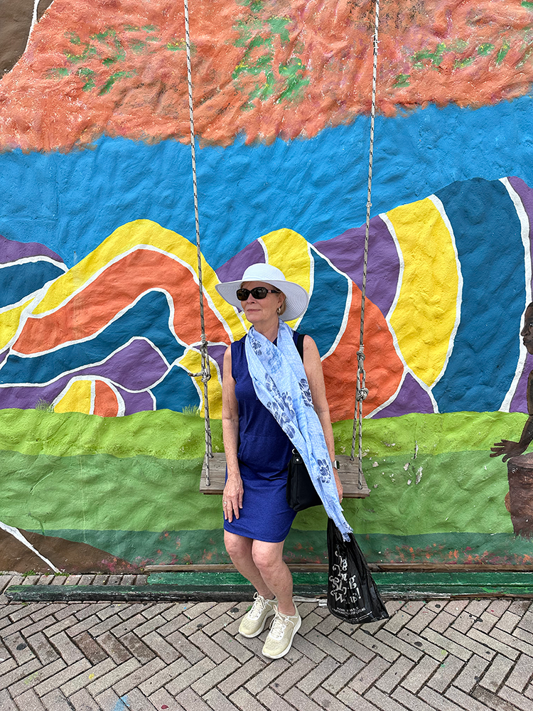 Jean swings in front of a colorful mural